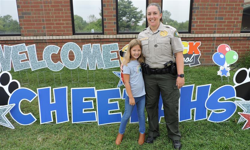 A student and school resource officer smile